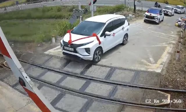 Ôtô chở khách đám cưới kẹt giữa gác chắn đường sắt khi tàu đến gần